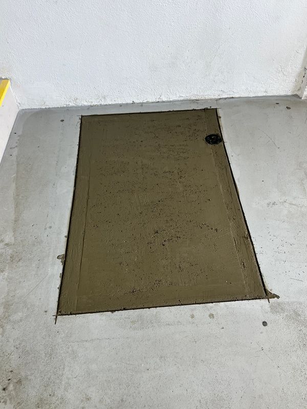 Fresh cement in garage after repipe and cleanout installation