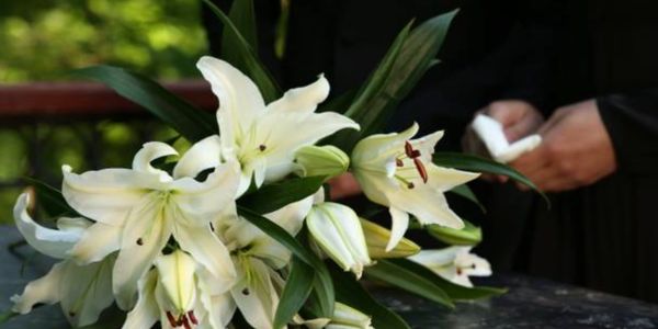White lilies decorating a closed coffin.