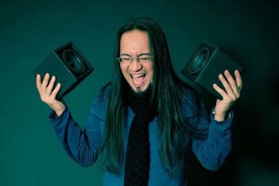 Man joyfully holding two speakers.