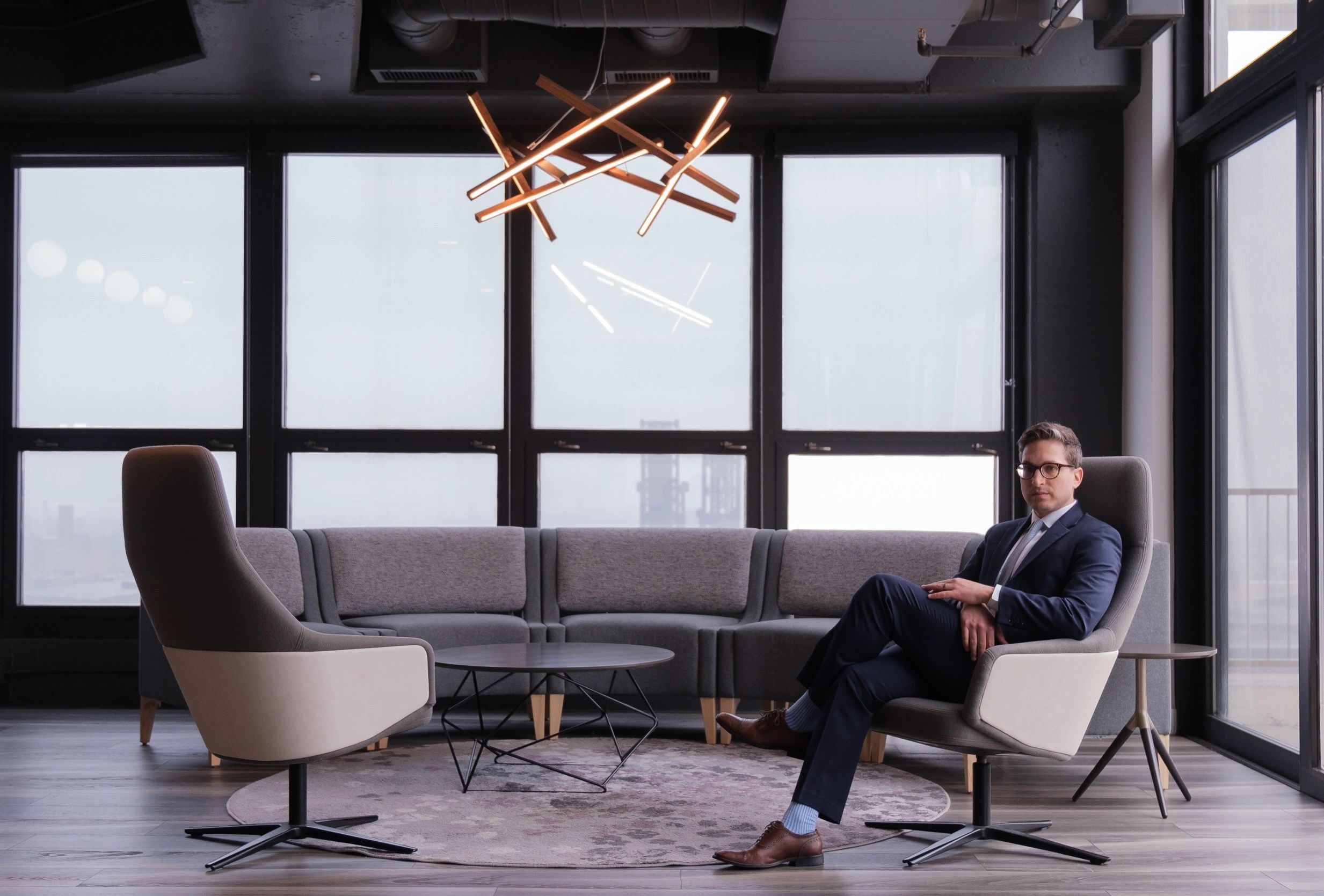Dr. Lemelman wearing a suit and tie while sitting in a modern office with his arms folded in Chicago