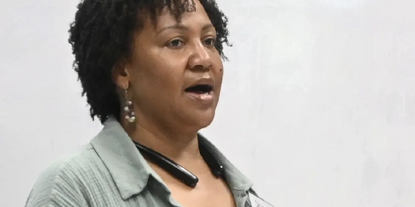 Woman speaking confidently in front of a whiteboard.