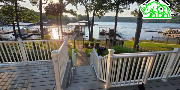 View from a deck overlooking a serene lake with docks and boats at sunset.