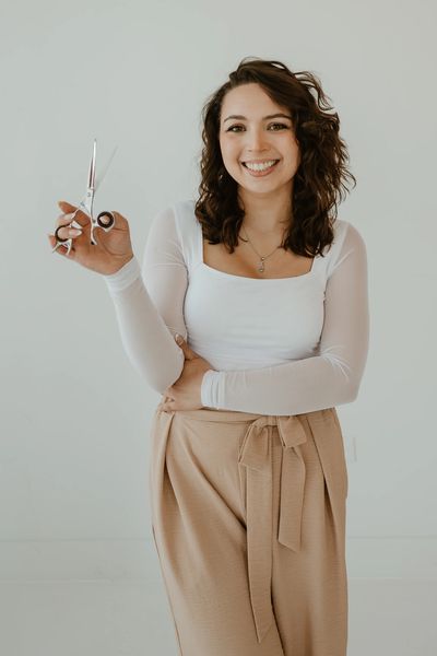Smiling woman holding scissors.