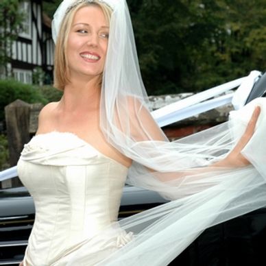 Photo of a Bride wearing a silk dupion corset and skirt, with tulle veil
