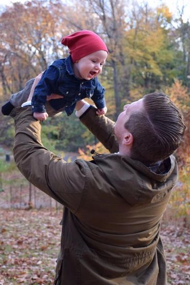 man carrying child in autumn