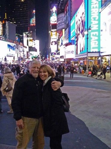 couple hugging with neon city behind them