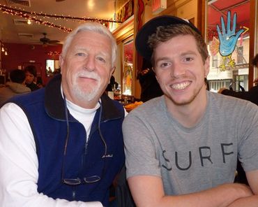 man with surf shirt next to man with blue vest