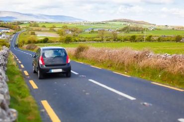 winding road with car and field