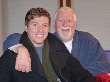 father and son smiling with white blinds