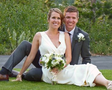 bride and groom sitting on the grass