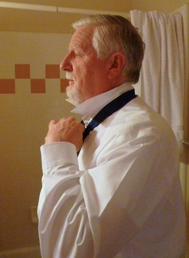 man with white shirt adjusting tie