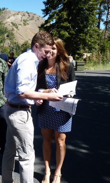 man and woman laughing while looking at papers