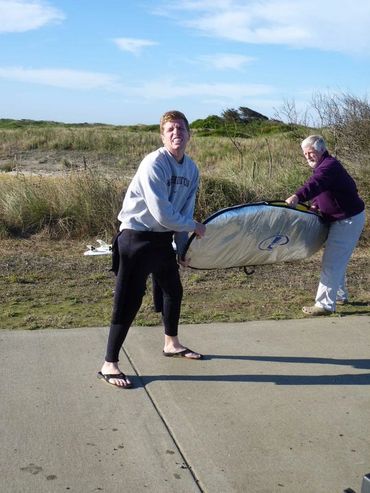 father and son carrying something with grass in background