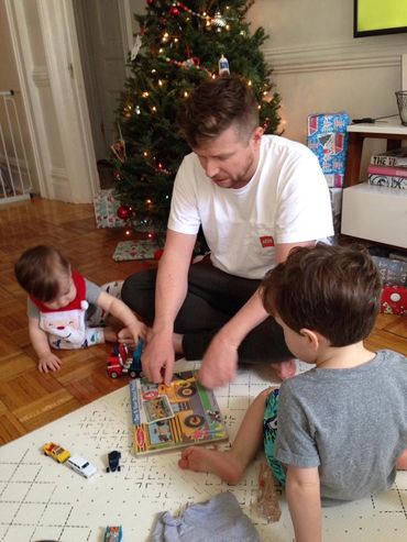 father playing with children on Christmas
