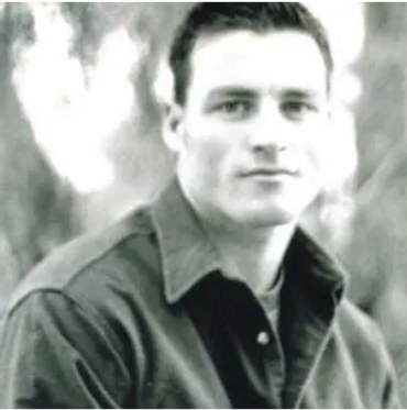 black and white photo of a man wearing a coat