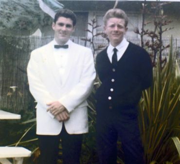Two men standing next to each other dressed in black and white