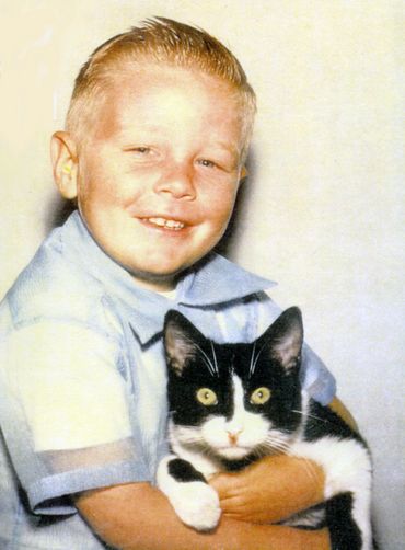 Gary hugging a black and white cat