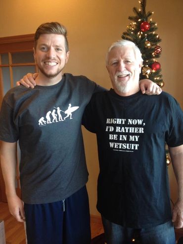 father and son posing for photo with Christmas tree