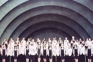 Grand Land singers performing with arched background