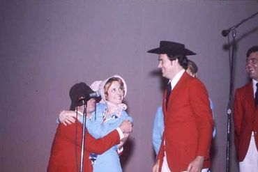 man and woman hugging against dark background