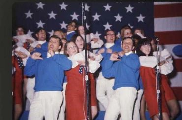 GLS members performing with two men in front