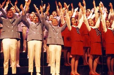 Grandland Singers performing with both arms raised