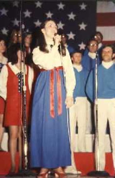woman in a red bow and blue skirt talking