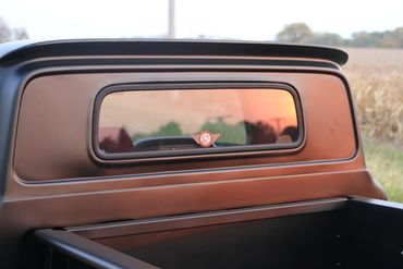 Rear window of matte black C10 in the sunrise with J5 Speedshop sticker at the bottom