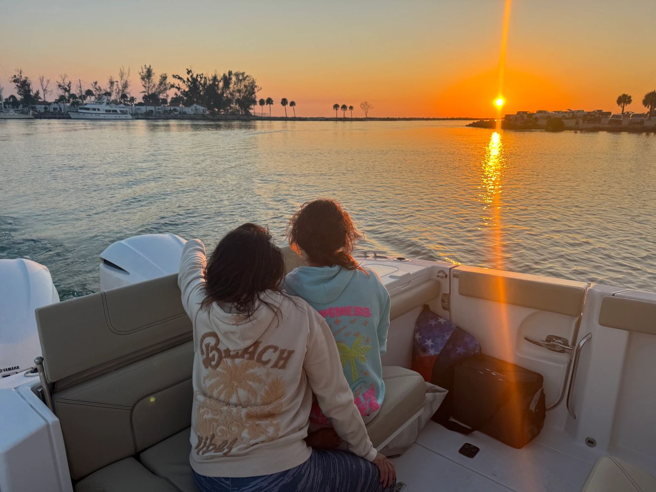 Two people enjoying a sunset from a boat