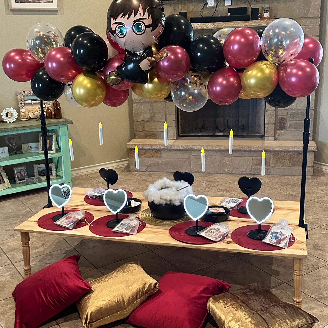 Harry Potter-themed party setup with balloons, floating candles, and cozy seating.
