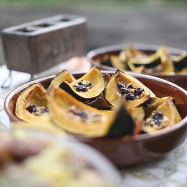 annual harvest dinner: Baked squash halves filled with nuts and dried fruits in a ceramic dish.