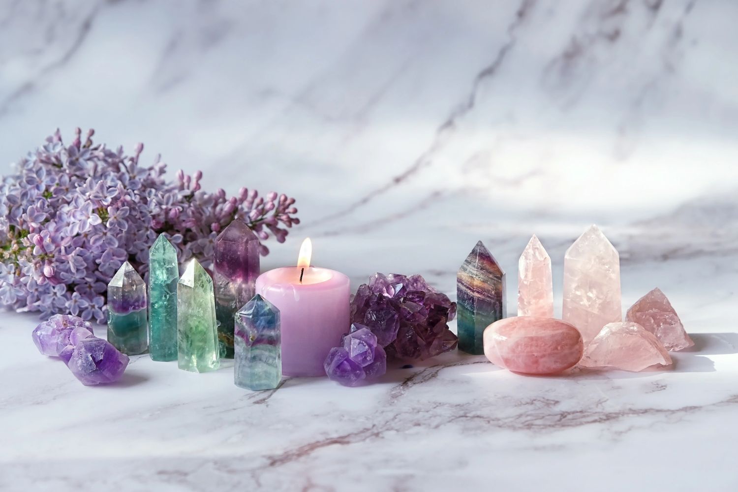Healing crystals, a glowing candle, and fresh flowers arranged to create a calming, sacred space.