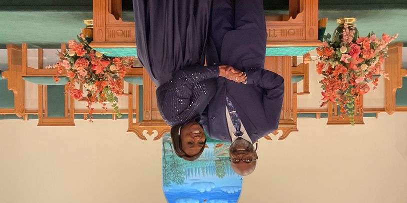 A smiling couple dressed formally standing inside a church.