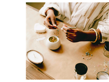black woman's hands above table making a candle