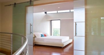 All glass barn style doors with custom frosted patterns sandblasted into the glass.