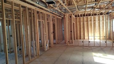 Interior of a building under construction showing wooden framing and ductwork.