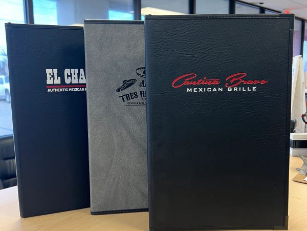 Three Mexican restaurant menus on a table.