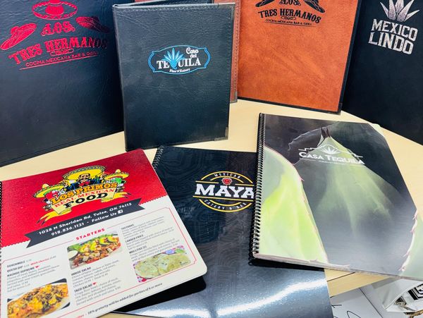 Collection of Mexican restaurant menus on a table.