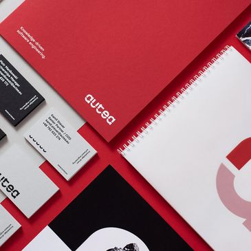 A stylish collection of branded stationery on a red background.