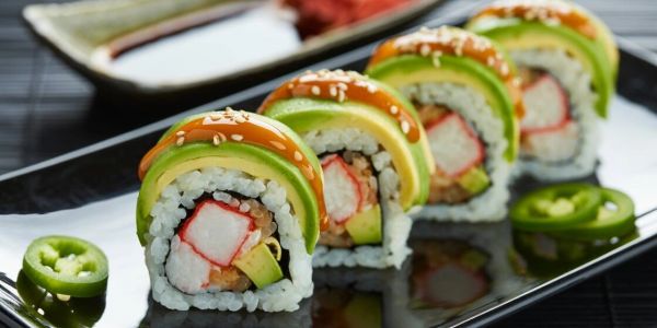 Colorful sushi rolls with avocado and jalapeño slices.