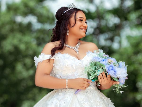 A woman wearing a wedding gown and holding flowers