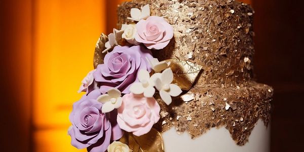 Couture cake featuring edible gold flakes and gumpaste flowers