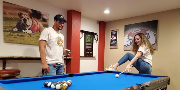 Our community care team member, Jay, I watching Maria pull off a trick shot in a game of pool. 