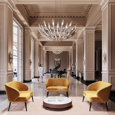 Elegant lobby with mustard yellow seating and grand piano under modern chandeliers.