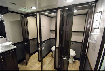 Interior luxury mobile restroom showing 3 stalls