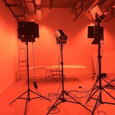 Photography studio with red lighting and professional studio lights.