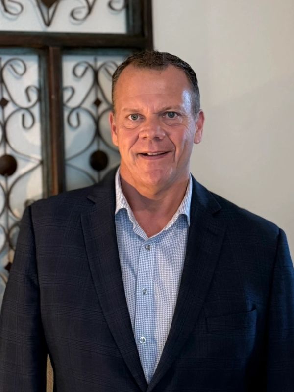 Man in a suit smiling at the camera.