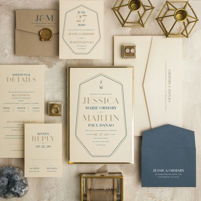 White wedding invitation with gold details and blue envelope. Wax seal matching stamp.