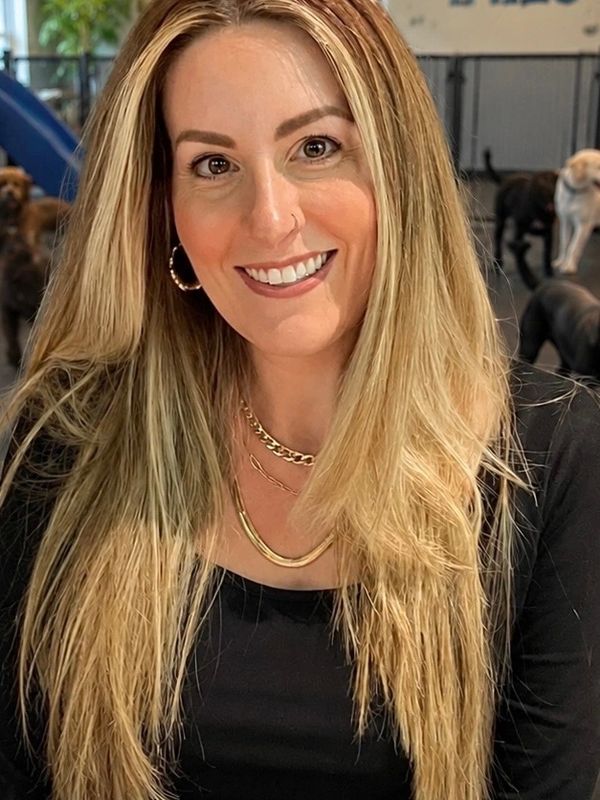 Smiling woman with long blonde hair in black top.
