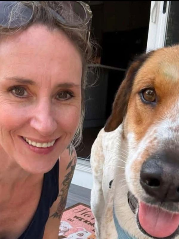 Woman smiling with a dog.